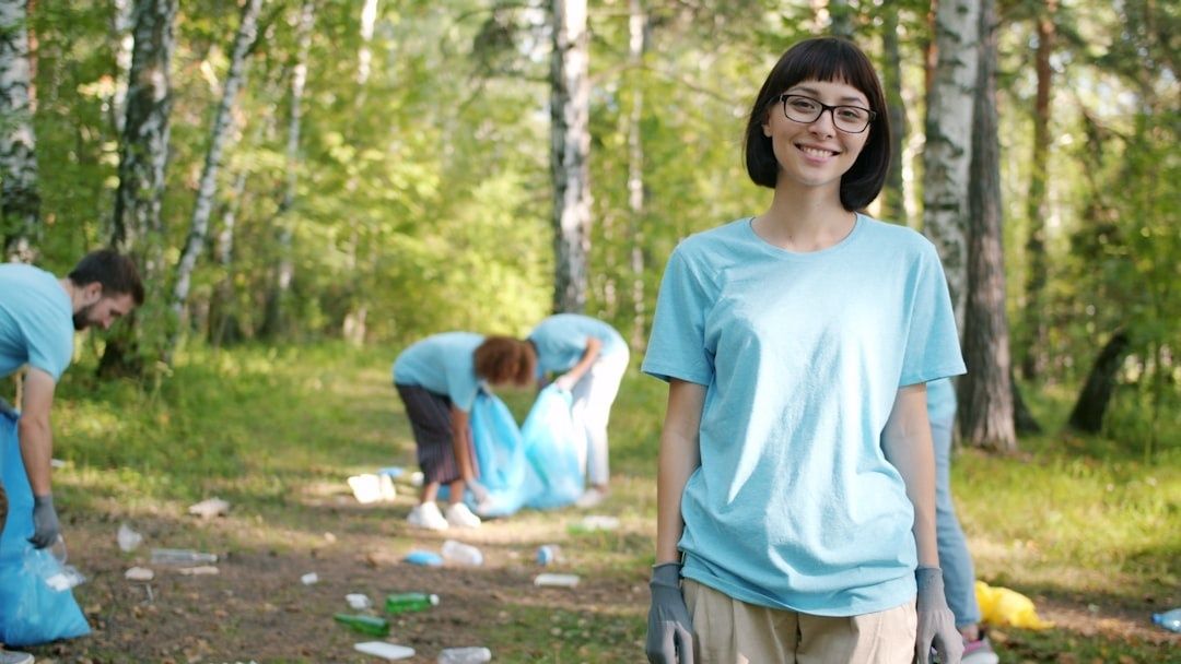 Talkoolaiset keräävät roskia metsäisessä tapahtumaympäristössä